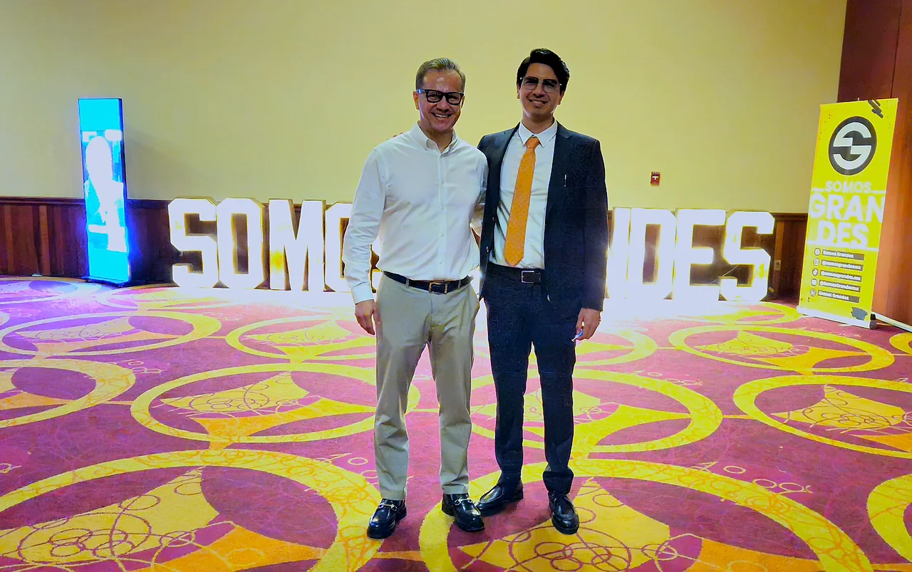 Mario Domínguez, gerente general de Somos Grandes, junto al Ing. Carlo J. Peña frente al letrero luminoso del evento en el hotel Galería Plaza Veracruz